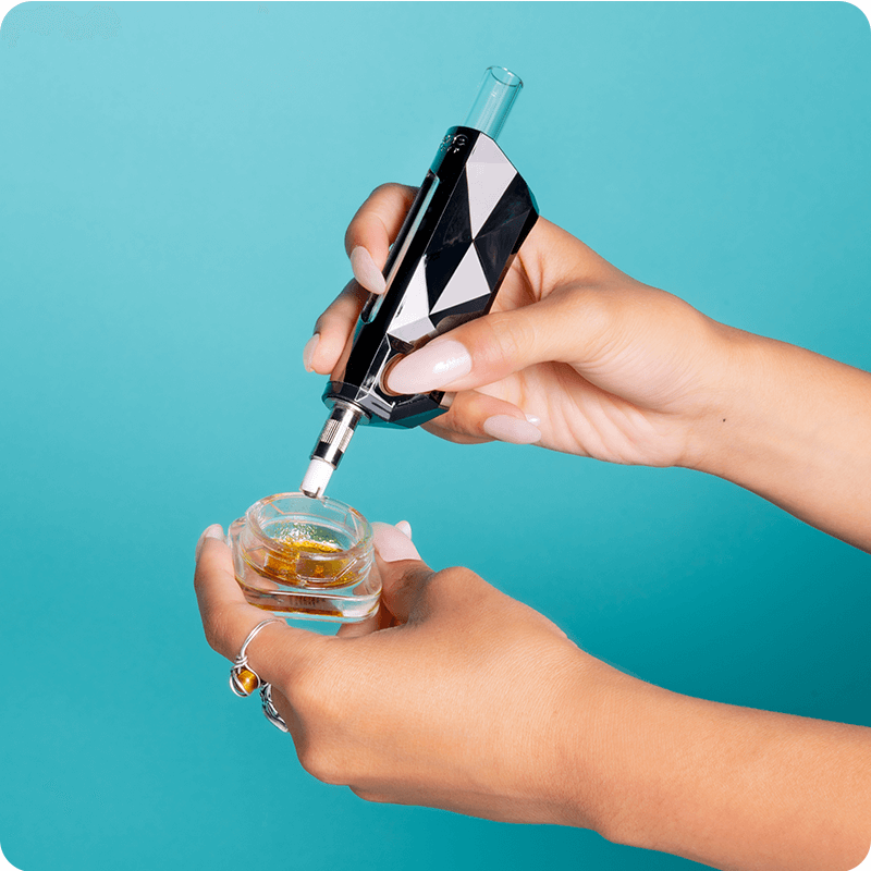 A girl dips the silver Ooze Pronto into a jar of OozeX Concentrates