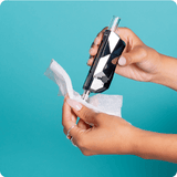 A girl uses an Ooze Resolution Res Wipe to clean the tip of a black Ooze Pronto
