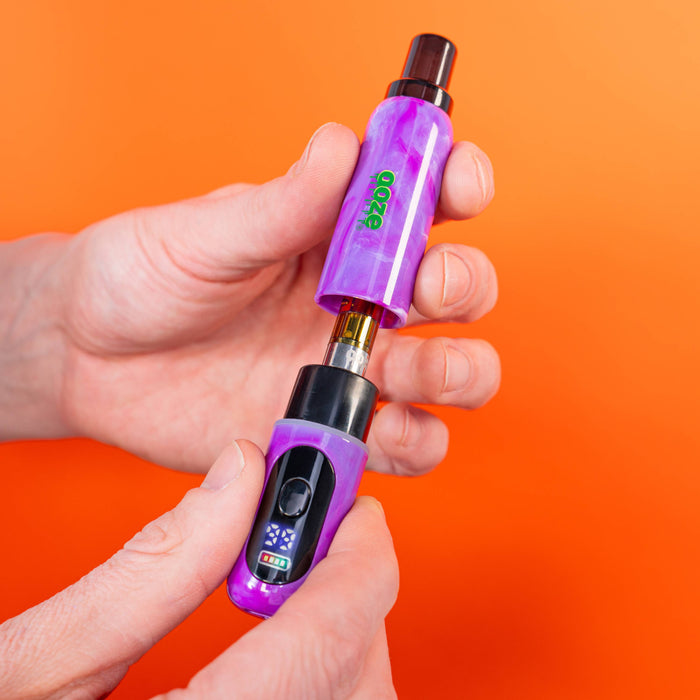 Holding purple Hivo battery pulling off the cap to show cart inside