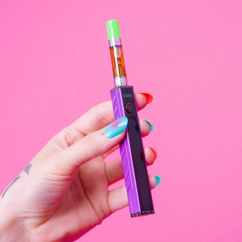 Holding a purple Quad 2 battery with a green-tipped cartridge