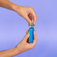 A girl with green nails is screwing a 510 cartridge into a blue Ooze Novex