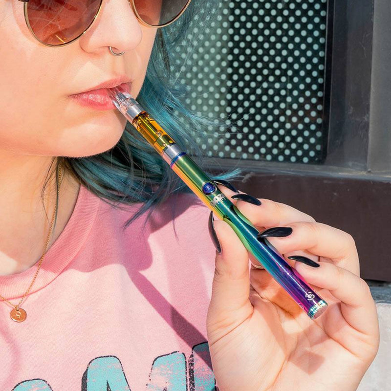 Taking a hit from a rainbow Twist Slim Pen 2.0 vape battery