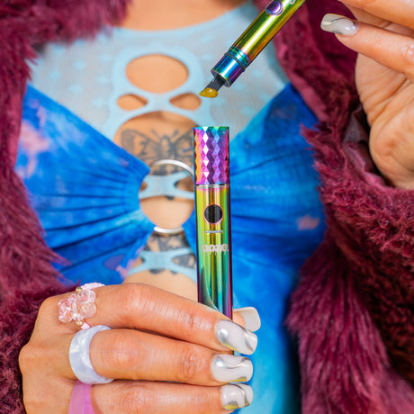 Loading a dab into a rainbow Ooze Beacon dab pen using a rainbow hot Knife