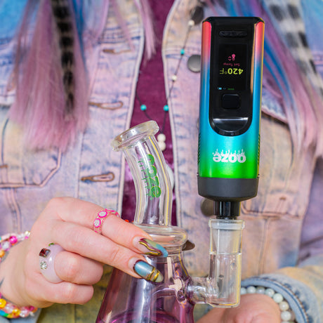 Person holding a glyco freeze bong with a rainbow Verge dry herb vape attached with the water pipe adapter