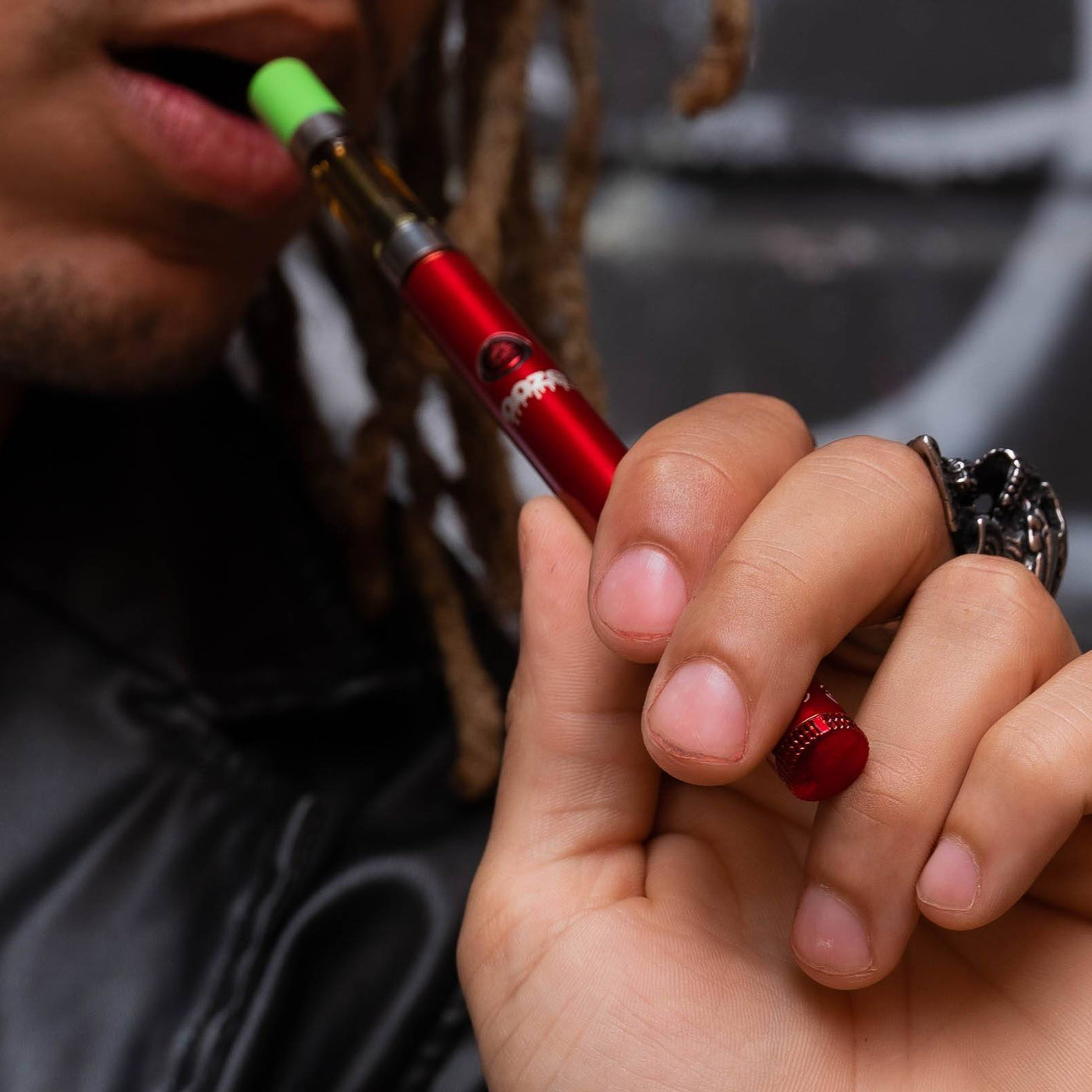 Taking a puff from a red Twist Slim Pen 2.0