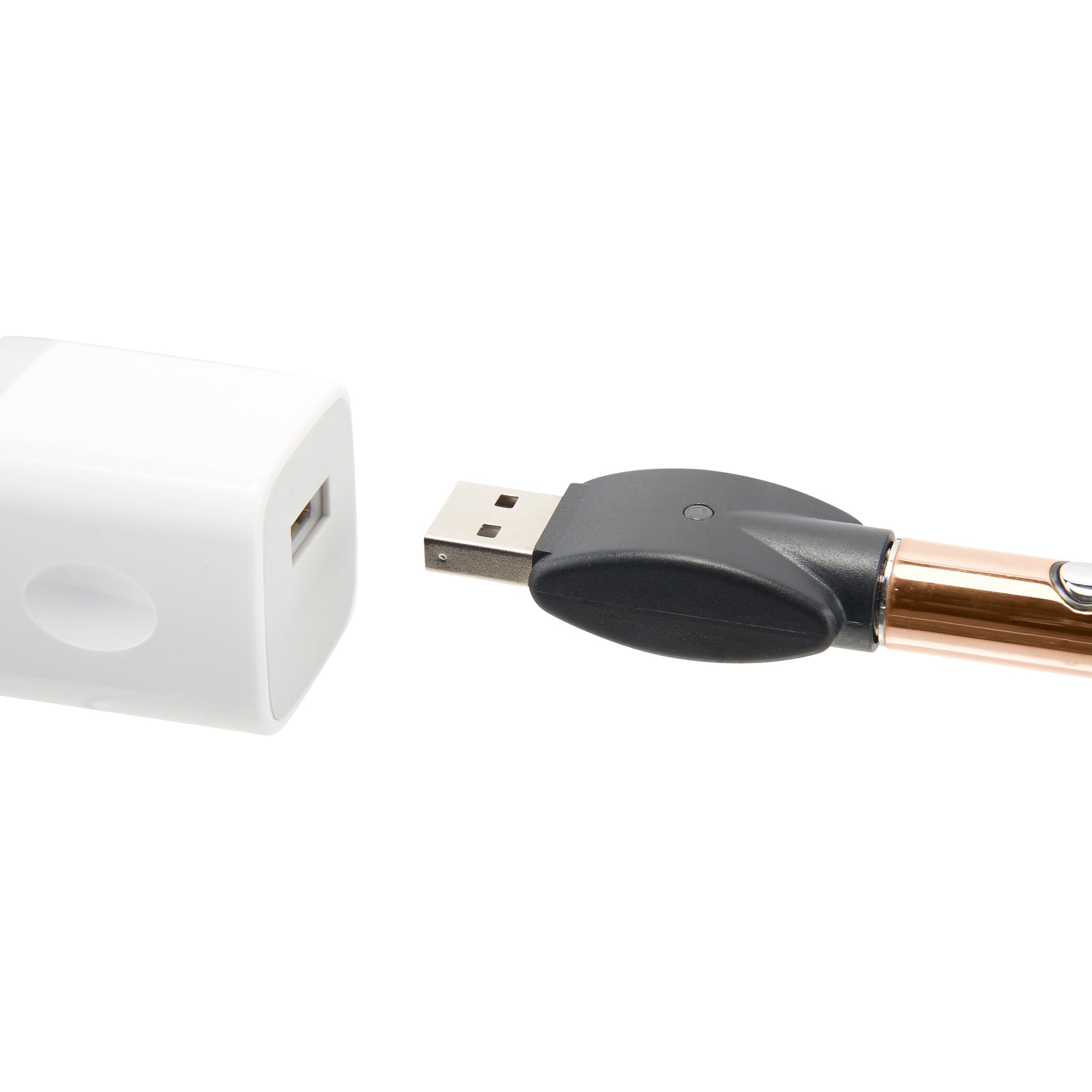 The rose gold Ooze Wink is plugged into its 510 charger, being plugged into a white USB wall adapter