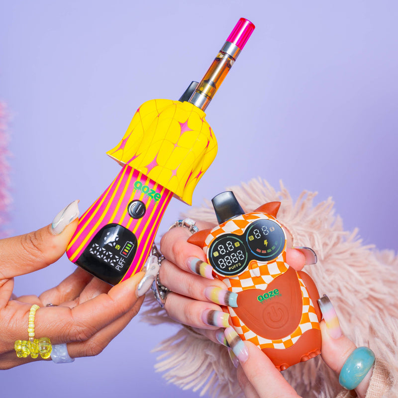 Hands holding a Shroom and hoot vape battery in front of a purple background