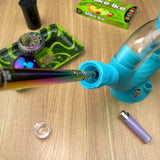 A rainbow Ooze pen is sticking out of the blue Ozone water pipe's armor bowl, being used as a vape adapter