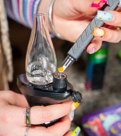 Loading a dab into a black Trigger e-rig with a hot knife