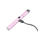 angled view of pink Signal wax pen lying down and charging