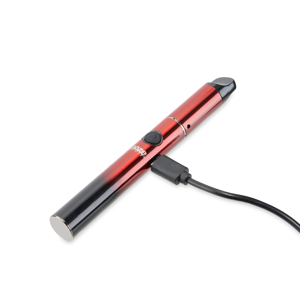 The Midnight Sun Ooze Signal wax vaporizer is laying on its side with the micro USB charger plugged into the port.
