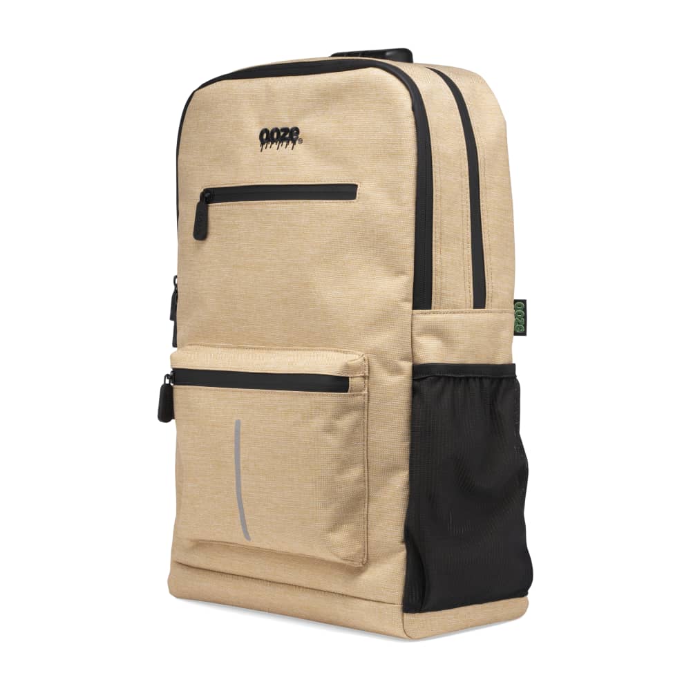 The desert sand Ooze backpack is zipped up and showing the side water bottle pocket