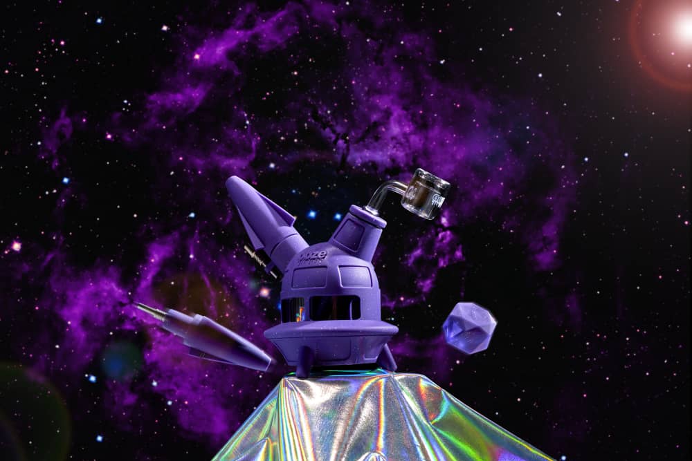 The shimmer purple Ooze UFO is shown as a dab rig against a purple black galaxy background, with the dab straw and stash jar floating nearby