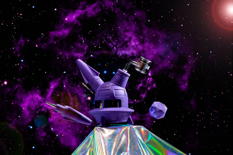 The shimmer purple Ooze UFO is shown as a dab rig against a purple black galaxy background, with the dab straw and stash jar floating nearby